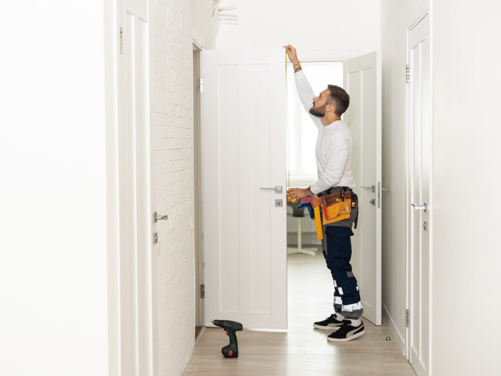 Best Door Installation for Perfect Interior Fit Best Door Installation by a skilled technician measuring an interior door for a precise fit, smooth operation, and lasting performance.