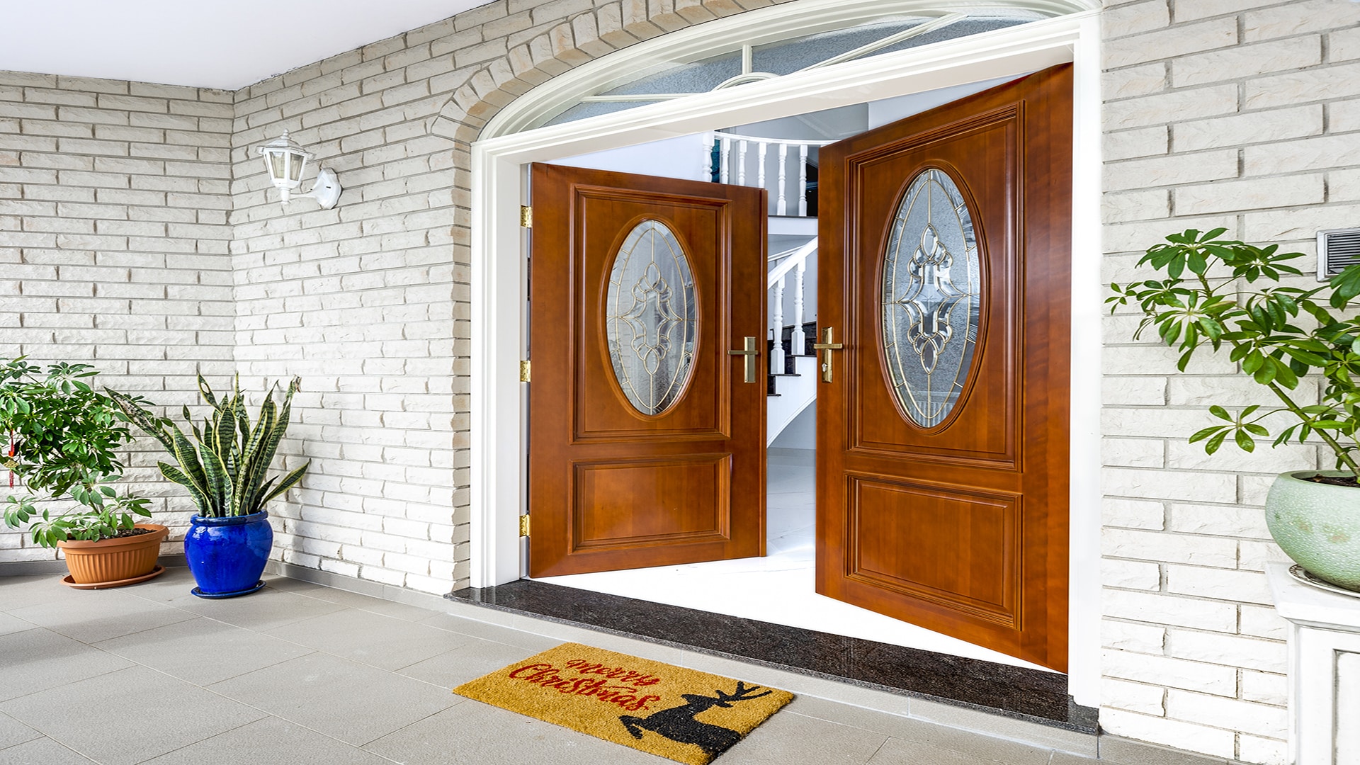 Door Installation Cost illustrated by an elegant wooden double entry door with decorative glass panels enhancing a home's entrance.