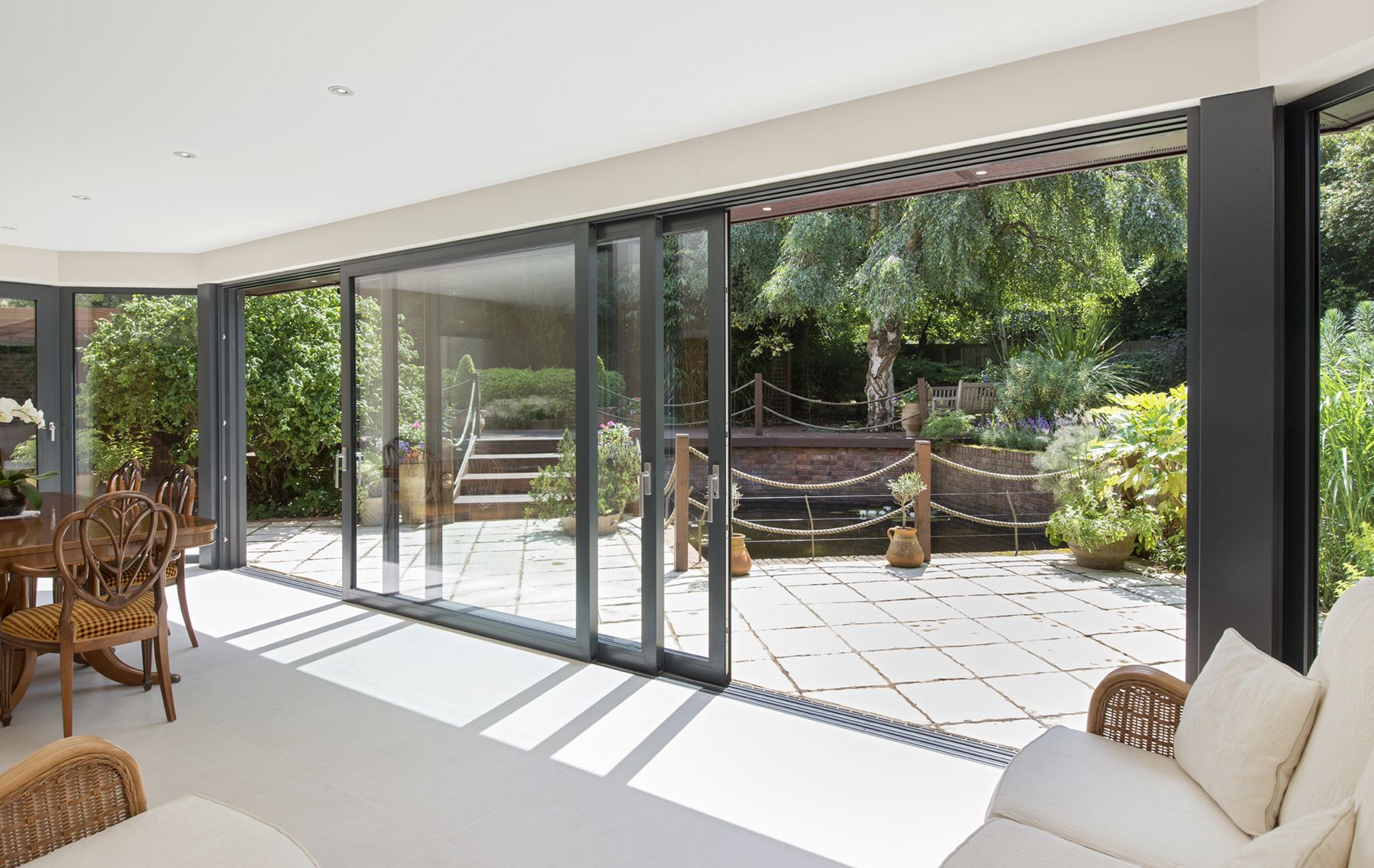 Patio Door Installation creating a bright, seamless connection between a stylish indoor living space and a beautiful outdoor patio.