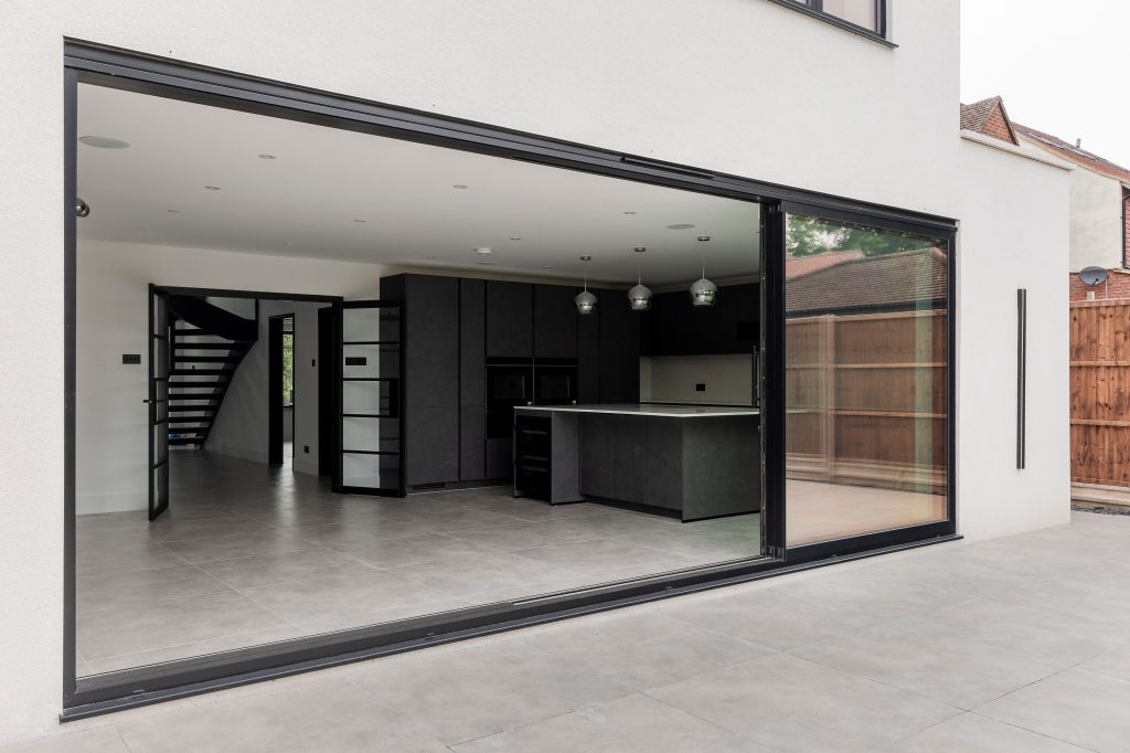 Large Patio Door Installation creating a sleek, open connection between the modern kitchen and outdoor patio.