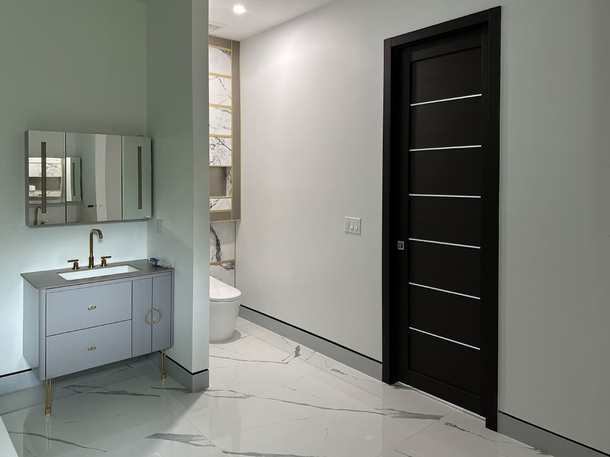 Modern bathroom featuring a stylish Pre-Hung Door, sleek vanity, and elegant marble flooring for a polished interior.