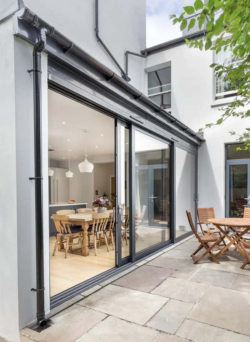 Patio Door Installation featuring sleek glass doors that connect a modern dining area with a spacious outdoor patio.