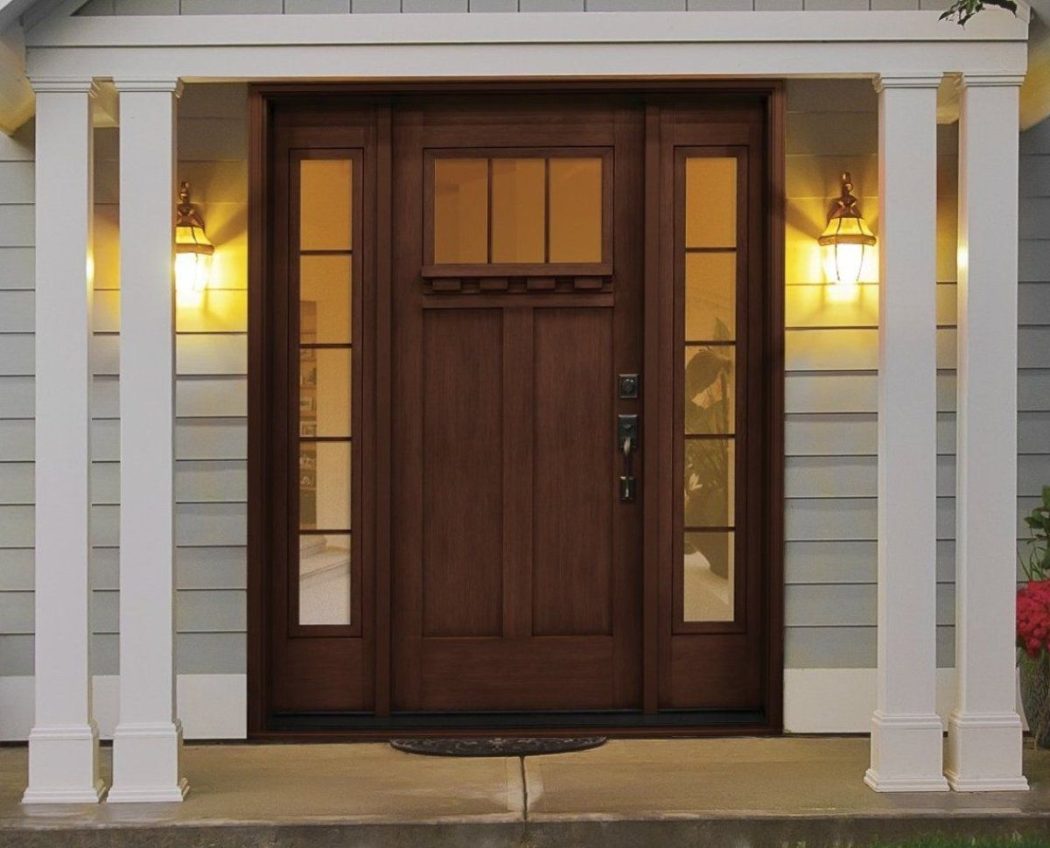 Residential Door Installation featuring an elegant dark wood double entry door with glass sidelights, white columns, and warm exterior lighting.