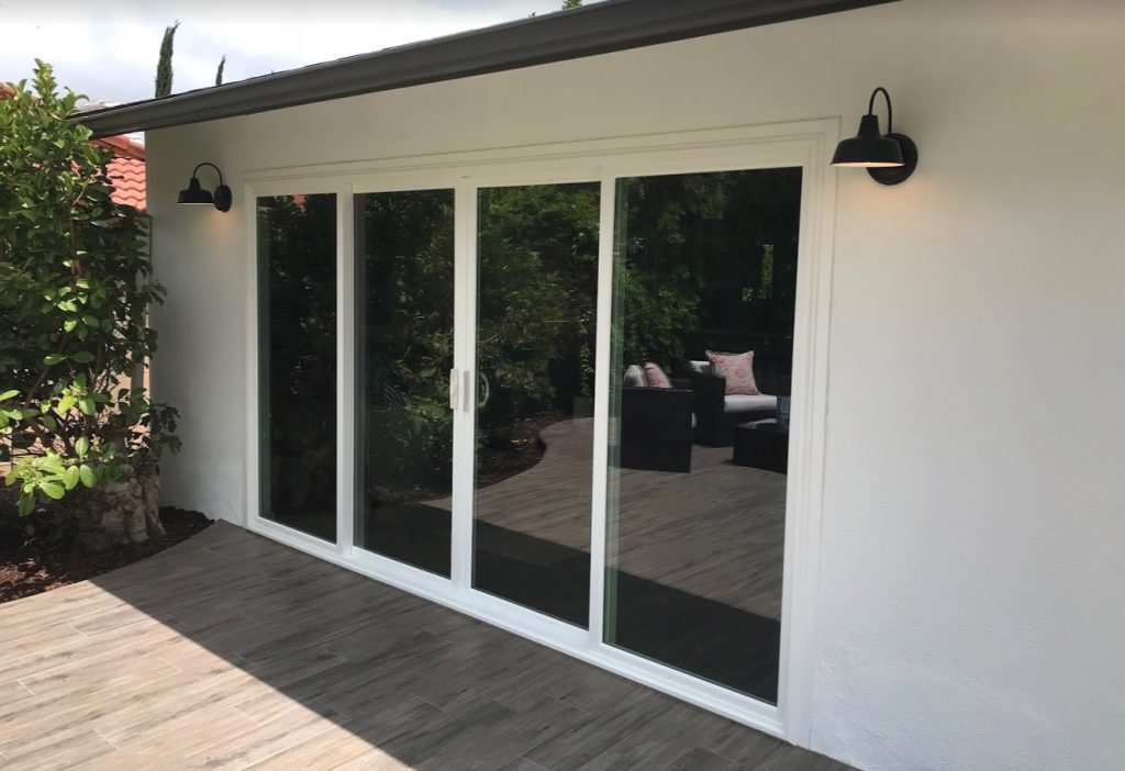 Patio Door Installation featuring sleek white-framed glass sliding doors opening onto a stylish outdoor deck.